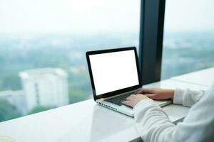 mujer trabajando por utilizando ordenador portátil blanco pantalla computadora . manos mecanografía en un tecnología de teclado comercio electrónico concepto. foto