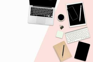 Flat lay photo of Office table with laptop computer, digital tablet, and mobile phone on modern two tone background.
