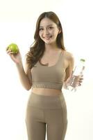 bonito asiático mujer con manzana y agua en blanco antecedentes. foto