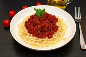 espaguetis a la boloñesa con salsa de tomate y carne foto
