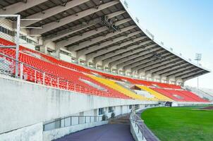 vacío naranja y amarillo asientos a estadio,filas pasarela de asiento en un fútbol estadio foto