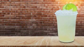 Cool freshly made lemonade in a plastic cups with crushed ice and lemon slices on wooden table with brick wall background photo