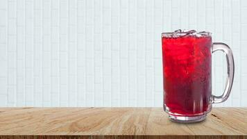 Fresco roselle jugo dulce agua y con hielo en vaso en de madera mesa con blanco fondo, verano salud bebidas con hielo, rojo jugo con hielo cubitos en vaso foto