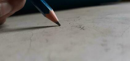 Pencil touching white surface depicting artist drawing designing photo