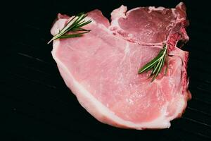 Top view raw pork chop steak on black background. photo