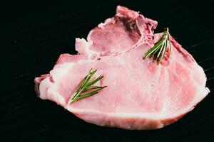 Top view raw pork chop steak on black background. photo