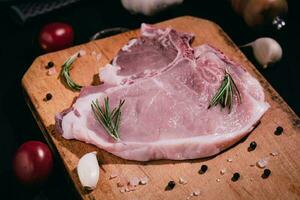 Pork chops on a cutting board with garlic, spices. Selective focus photo