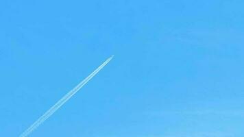 Contrails in the blue sky. Airplane flying high. Slow motion video