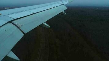 View of the wing of a jet plane from the window when landing. Travel and air transportation concept video