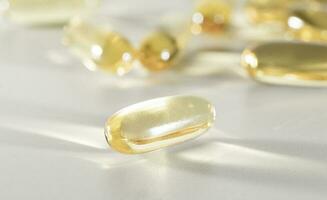 vitamina re amarillo suplemento gel cápsulas, pescado petróleo omega 3 en blanco fondo, macro Disparo foto