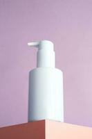 Blank white pump bottle on podium isolated photo