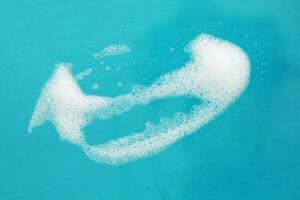 White soap suds isolated on blue background photo