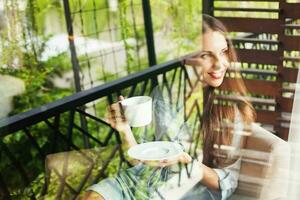 woman drinking tea at home. View through the window photo