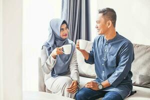 hermosa indonesio musulmán Pareja Bebiendo café a hogar foto