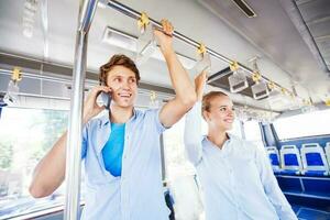 man and woman traveling by bus, man talking on phone photo