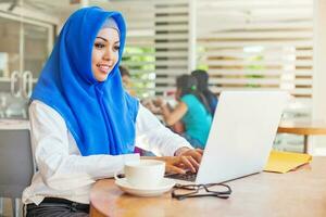 Muslim asian woman working in office with laptop photo