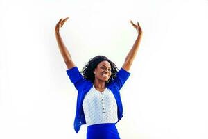 un joven relajado y contento africano mujer vistiendo formales en pie con su manos arriba foto