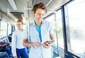 man  traveling by bus and checking map on his smartphone photo