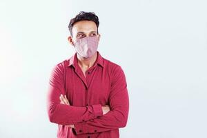 Indian young man wearing face mask over white studio background photo