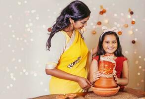 hermosa indio madre y hija Orando y haciendo puja con kalasha en navratri dias foto