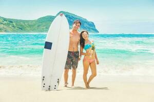 hermosa navegar Pareja en un playa de Indonesia foto