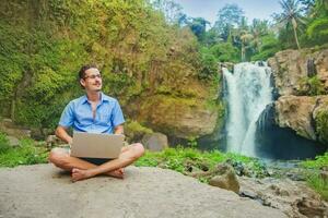 successful man with laptop in a jungle photo