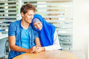 musulmán Pareja en amor a hogar. ambos vistiendo azul ropa foto