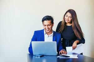 Two Indian colleagues working on the project, using laptop in the office photo