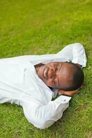 Afro businessman laying on the grass photo