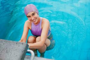 caucásico mujer en Clásico nadando gorra posando como un profesional nadador foto