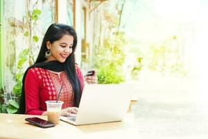 Pretty young indian woman in traditional clothes shopping online photo