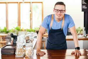 handsome restaurant owner standing in front of the coffee bar photo