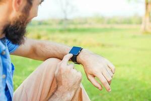 Man clicking on his smart watch. Template for smartwatch app design photo