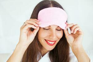 woman preparing to go to sleep and putting on a sleeping mask photo