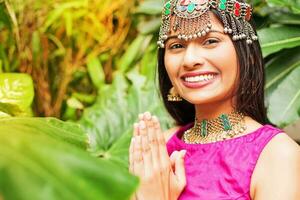 beautiful indian woman wearing traditional dress greeting with namaste photo