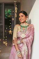 Gorgeous Indian woman in mauve banarasi saree and heavy bridal jewelry photo