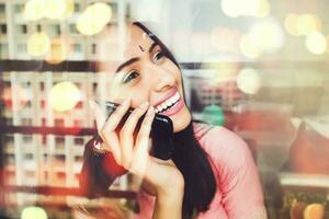 young beautiful happy indian woman talking on phone photo