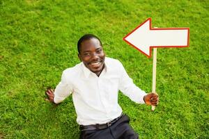 black man sitting on a grass with an arrow photo