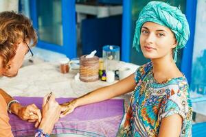 woman getting a henna tattoo by an artist photo