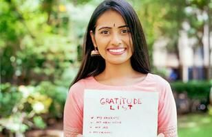 young indian woman standing with a placard in hands photo