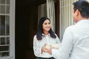 Young Indian woman receiving delivery package photo