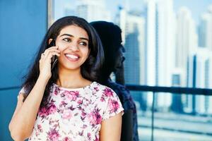 Beautiful south indian woman talking on phone in a city photo