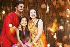 Beautiful Indian family in traditional ethnic clothes with little girl cheerfully looking forward photo