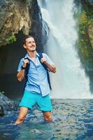 hombre teniendo un aventurero rastreo cerca el cascada foto