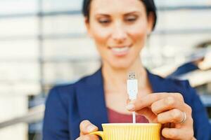 Internet de cosas. mujer utilizando un inteligente USB taza foto