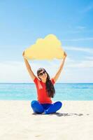 Cloud storage concept. Woman holding paper cloud icon on the beach photo