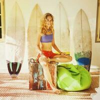 Amateur style filtered portrait of a relaxing surfer girl at home photo