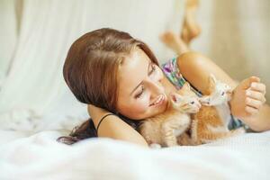 mujer relajante en un cama con un muy linda gatito foto