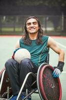 handsome determined disabled rugby player in a wheelchair practicing on a stadium photo
