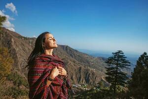 Beautiful woman with closed eyes in front of Himalaya mountains in Dharamshala, India photo